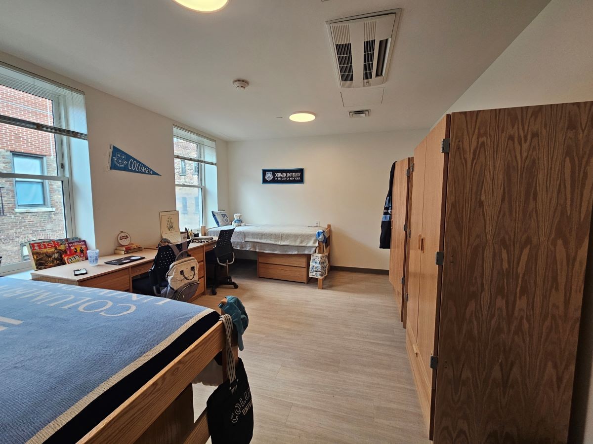 double room showing two beds, two desks, and two dressers