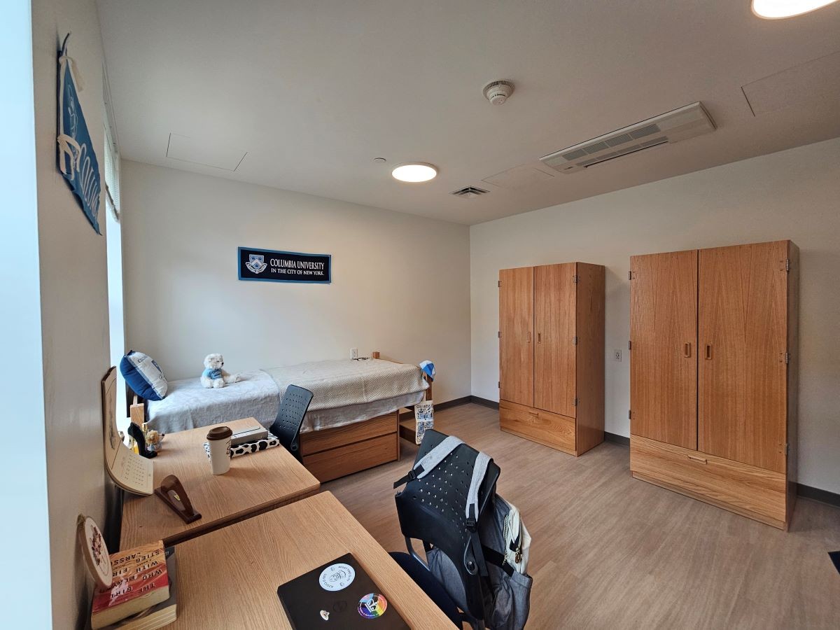 double room showing only one bed, two desks, and two dressers