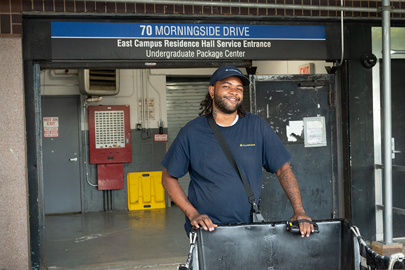 A Mail Center worker pushing a bin