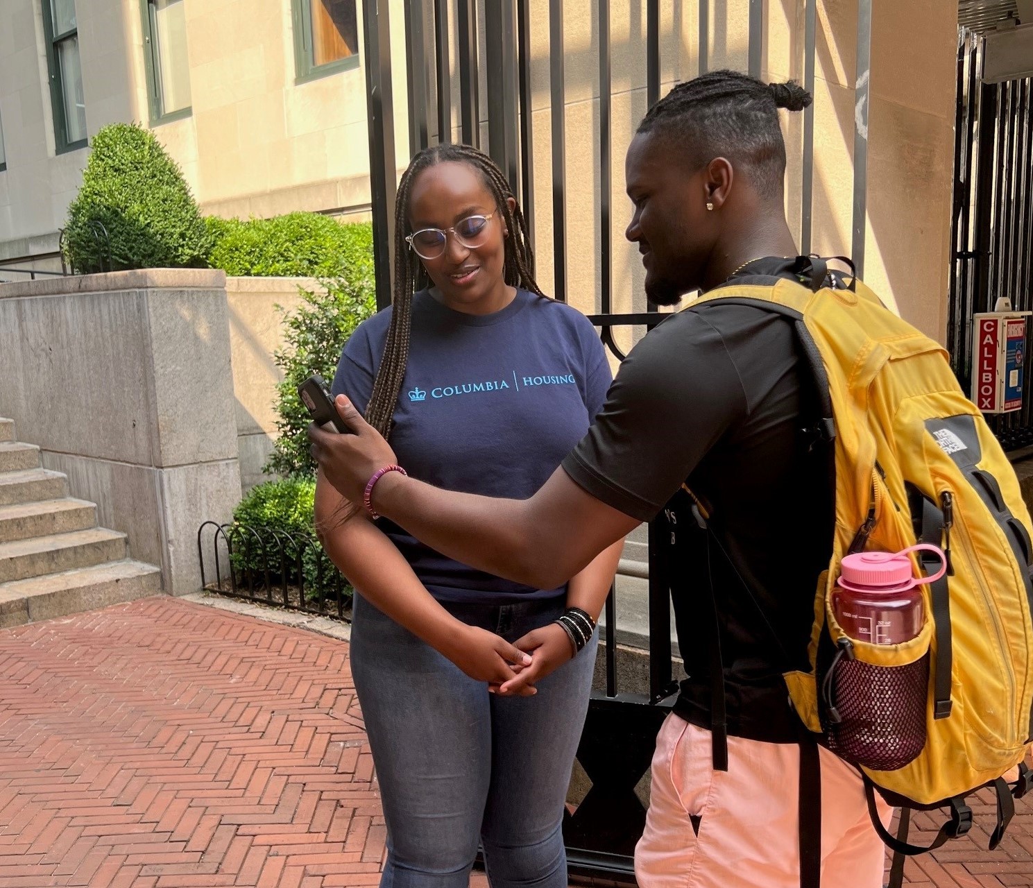 A student showing his Lion Pass on his phone to a Housing staff member
