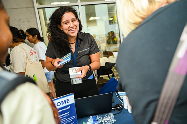 A Housing staff member greeting first-year students at Check-In