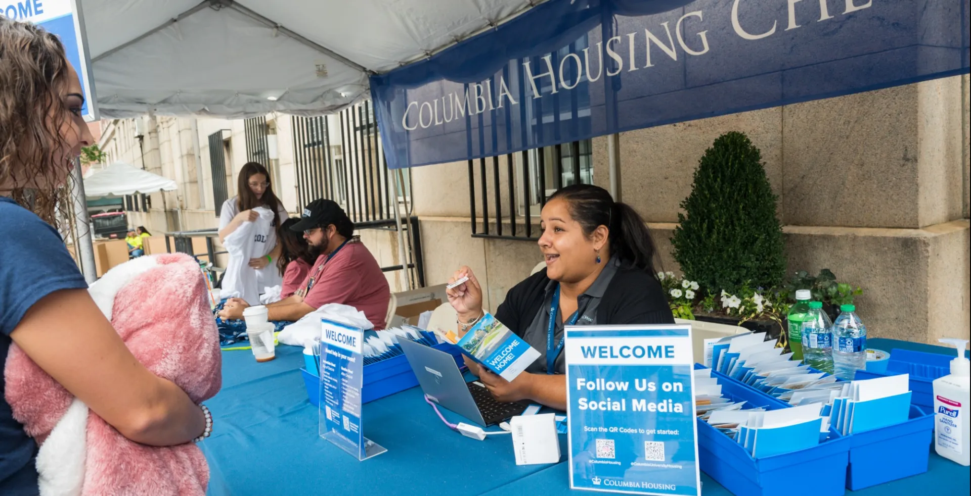 A staff member helping a student at check-in
