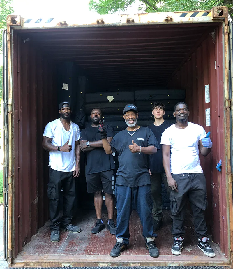 A work crew stands at the entrance to a cargo container