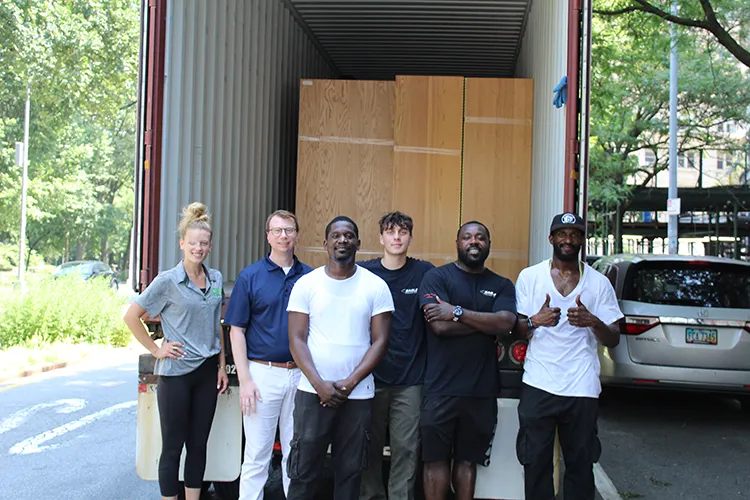 The IRN team and a Housing worker stand in front of a full cargo truck