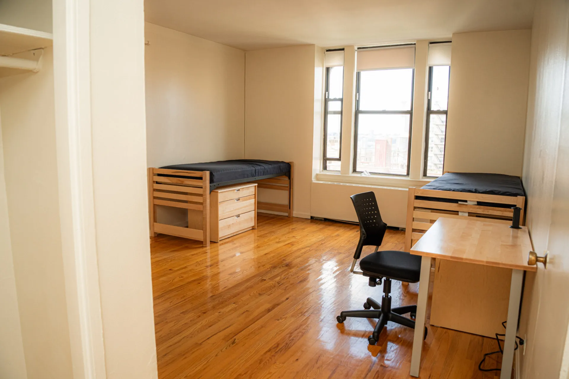 Two beds and a desk in a studio double room in 542 West 112th Street
