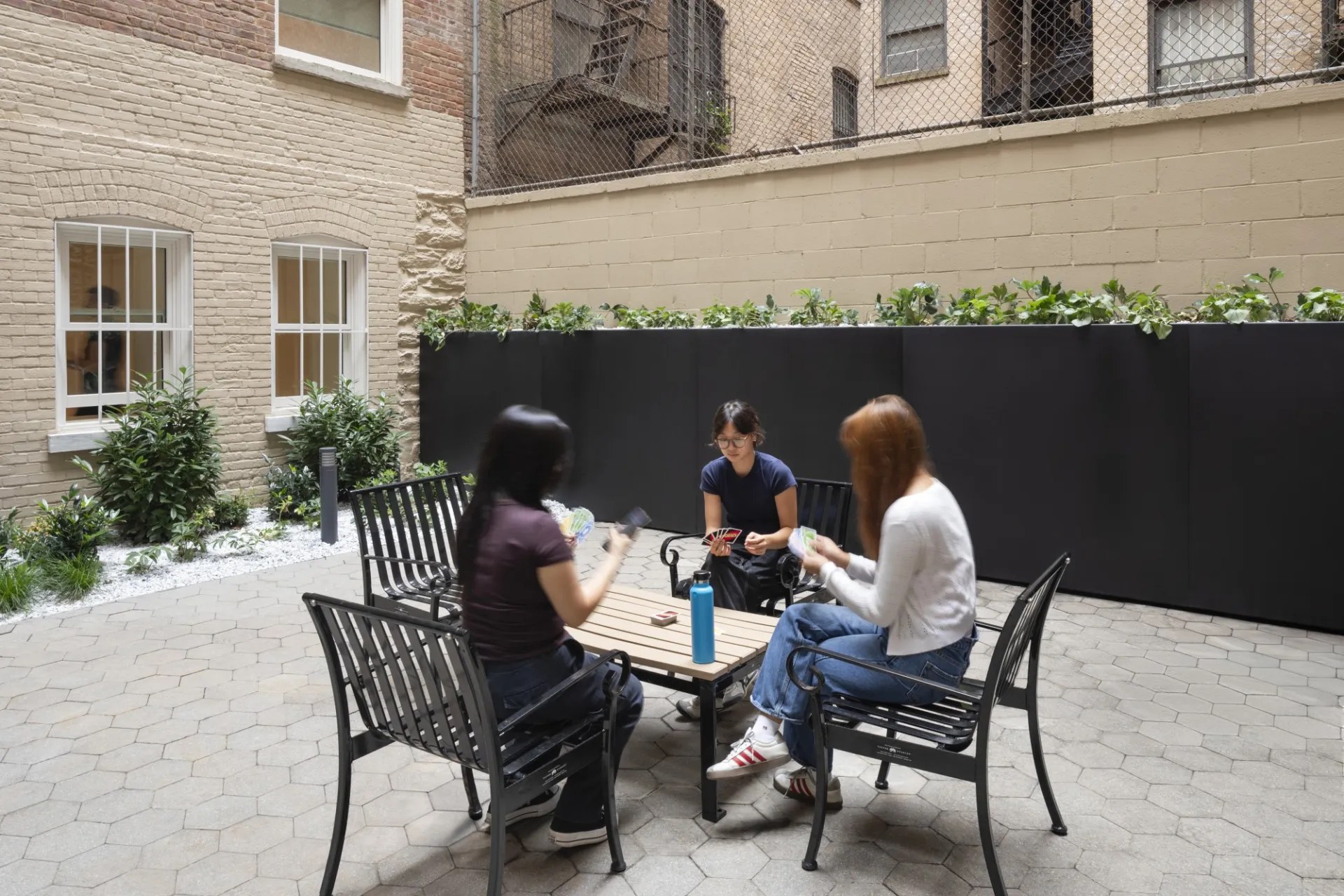 Students hanging out and playing cards in the outdoor courtyard