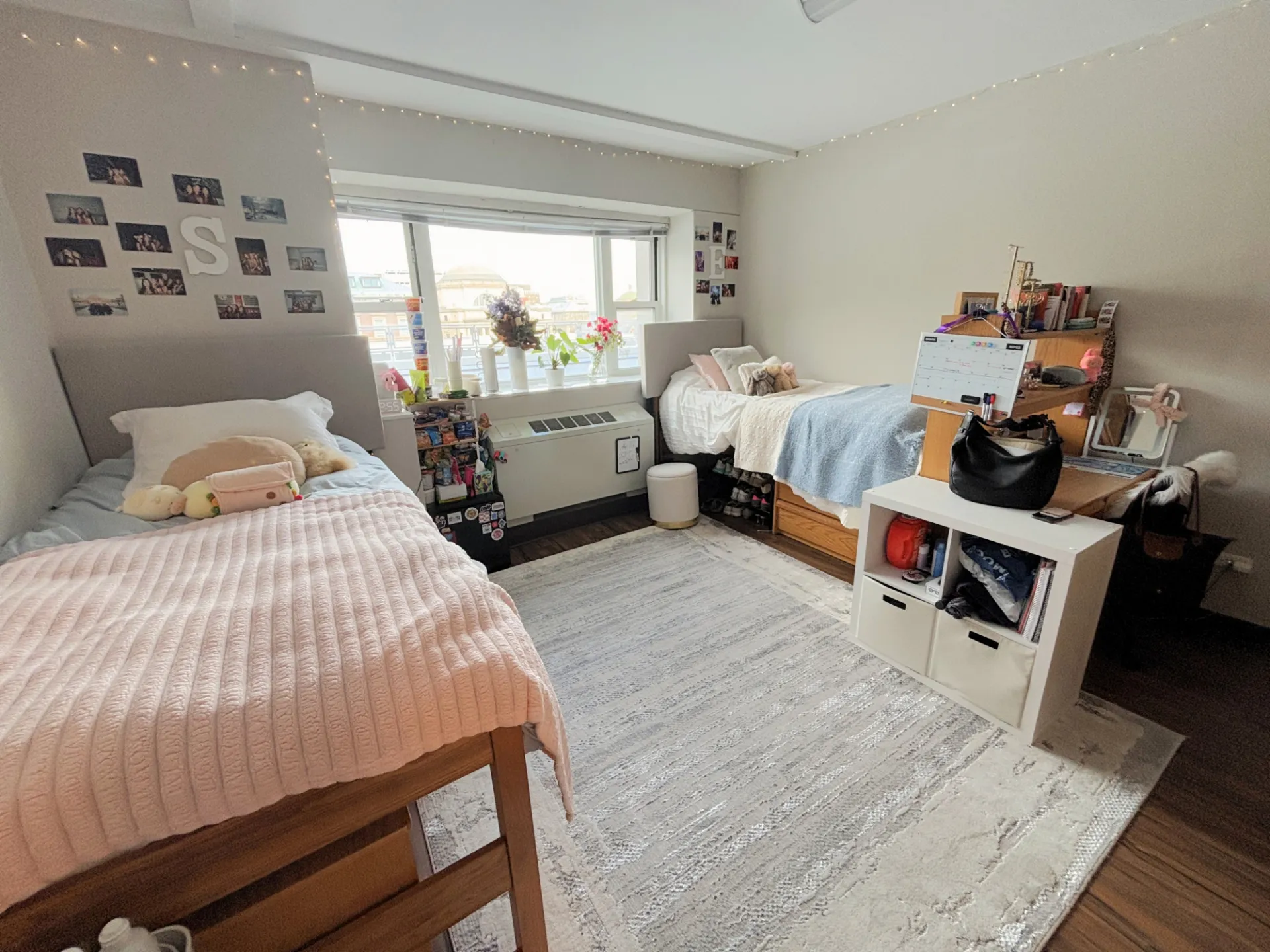 A decorated, sunlit room in Carman Hall showing two beds and a desk