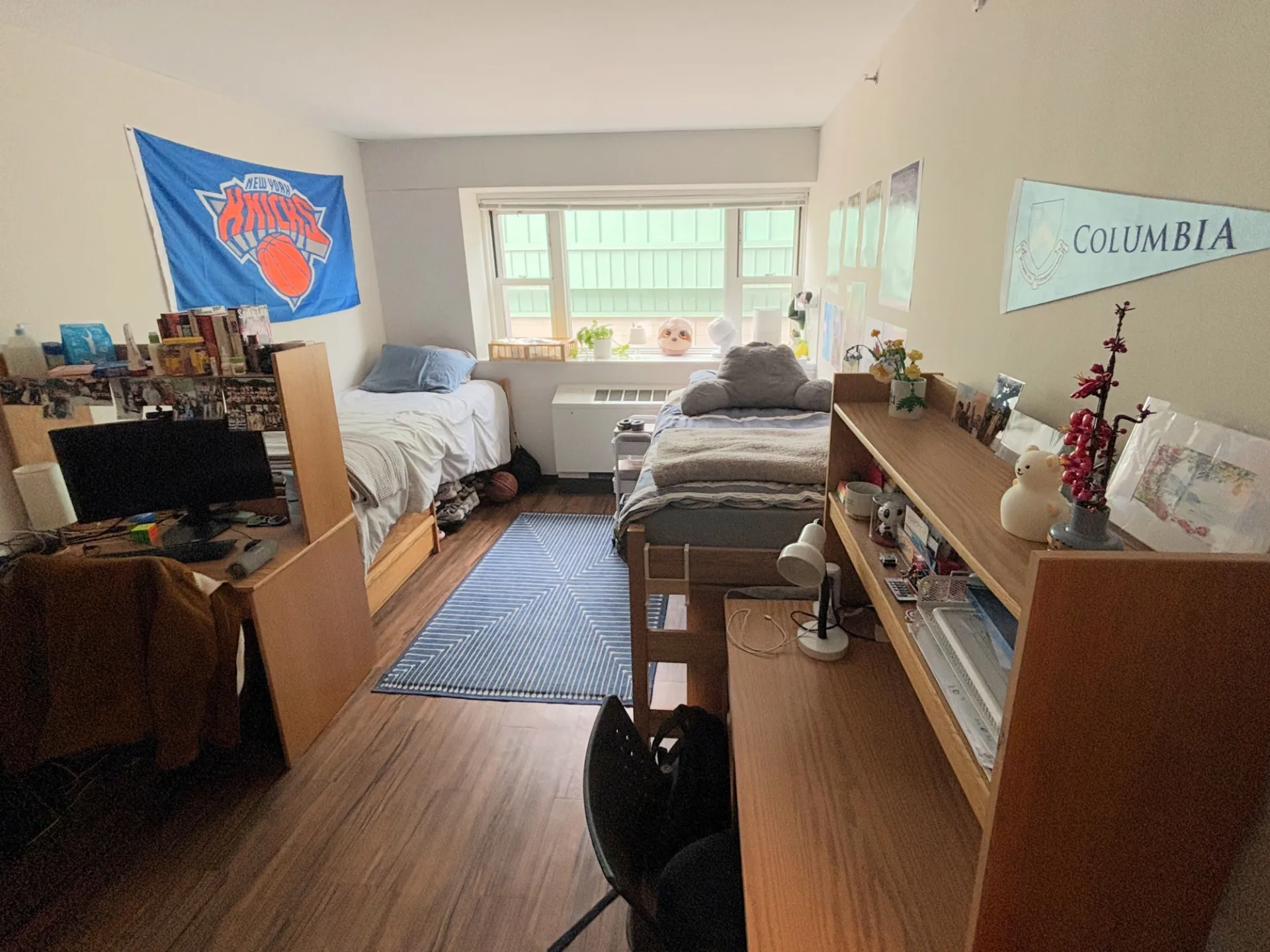 Double room in Carman Hall showing two beds, two desks, and a large window in the back of the room.