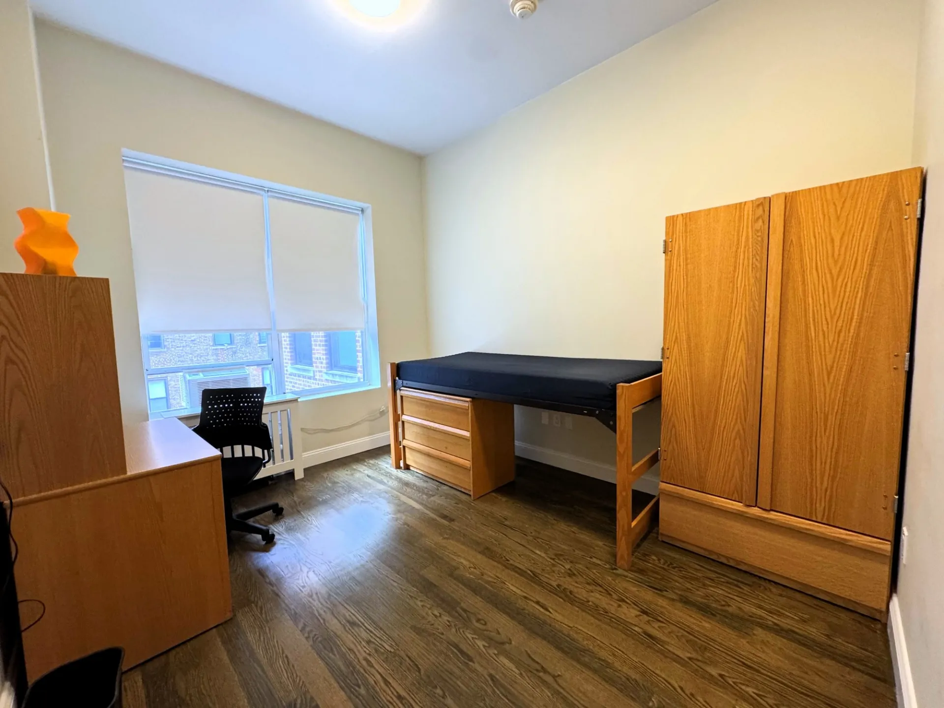Single room with bed, armoire, and desk and chair
