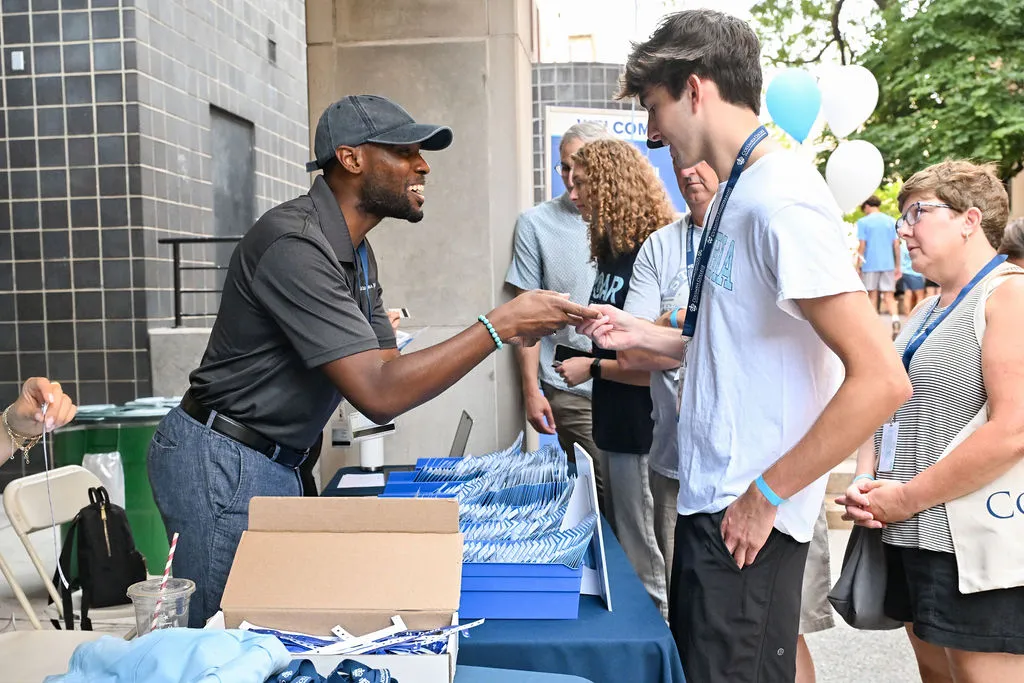 A Housing staff member helps a student at Check-In
