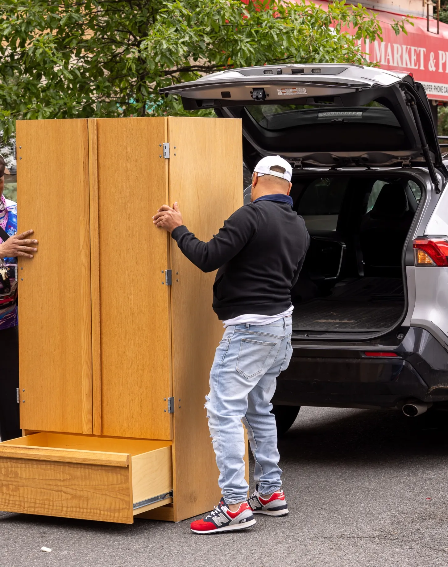 New owner of donated armoire loads the item into car