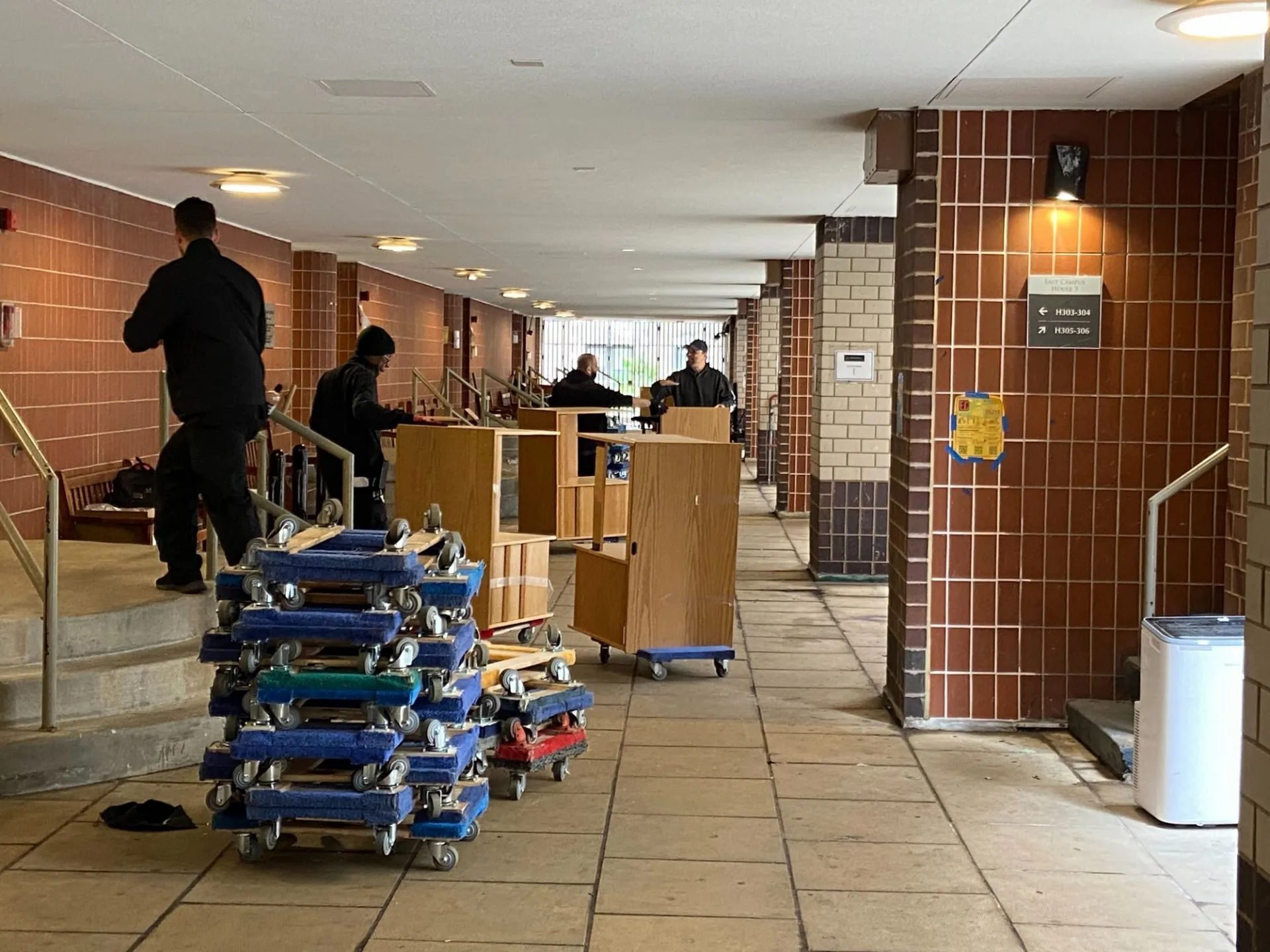 Desks are loaded onto carts to be transported out of campus