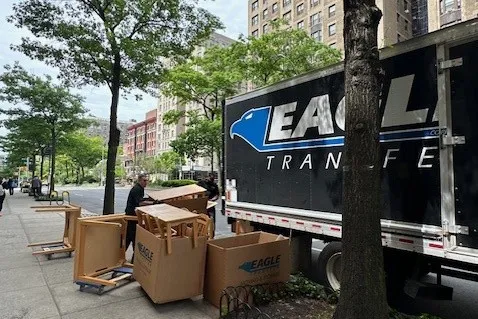 The moving company loads the donated items into the truck to be transported. 
